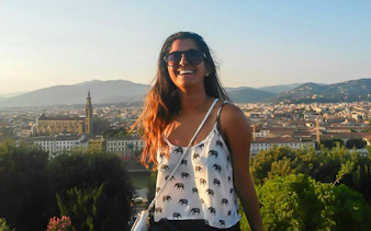 Smiling tourist overlooking Florence skyline with Basilica of Santa Croce in view.