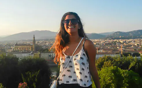 Smiling tourist overlooking Florence skyline with Basilica of Santa Croce in view.