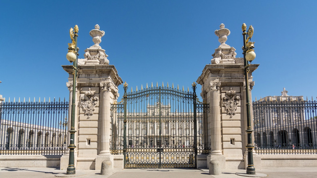 Royal Palace of Madrid entrance with tourists exploring the historic architecture.