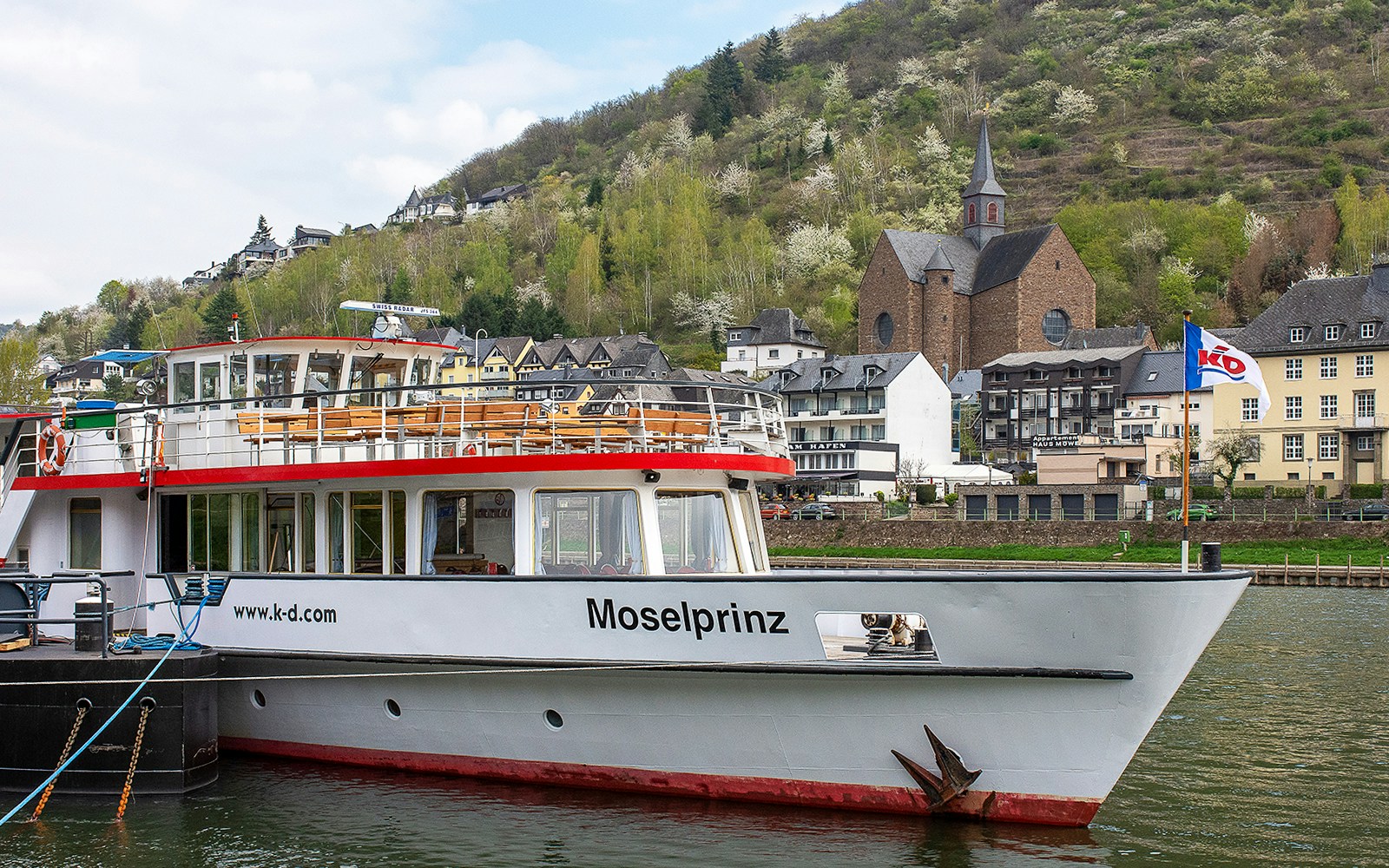 River cruise boat on the Moselle River with Cochem's Reichsburg Castle in the background.