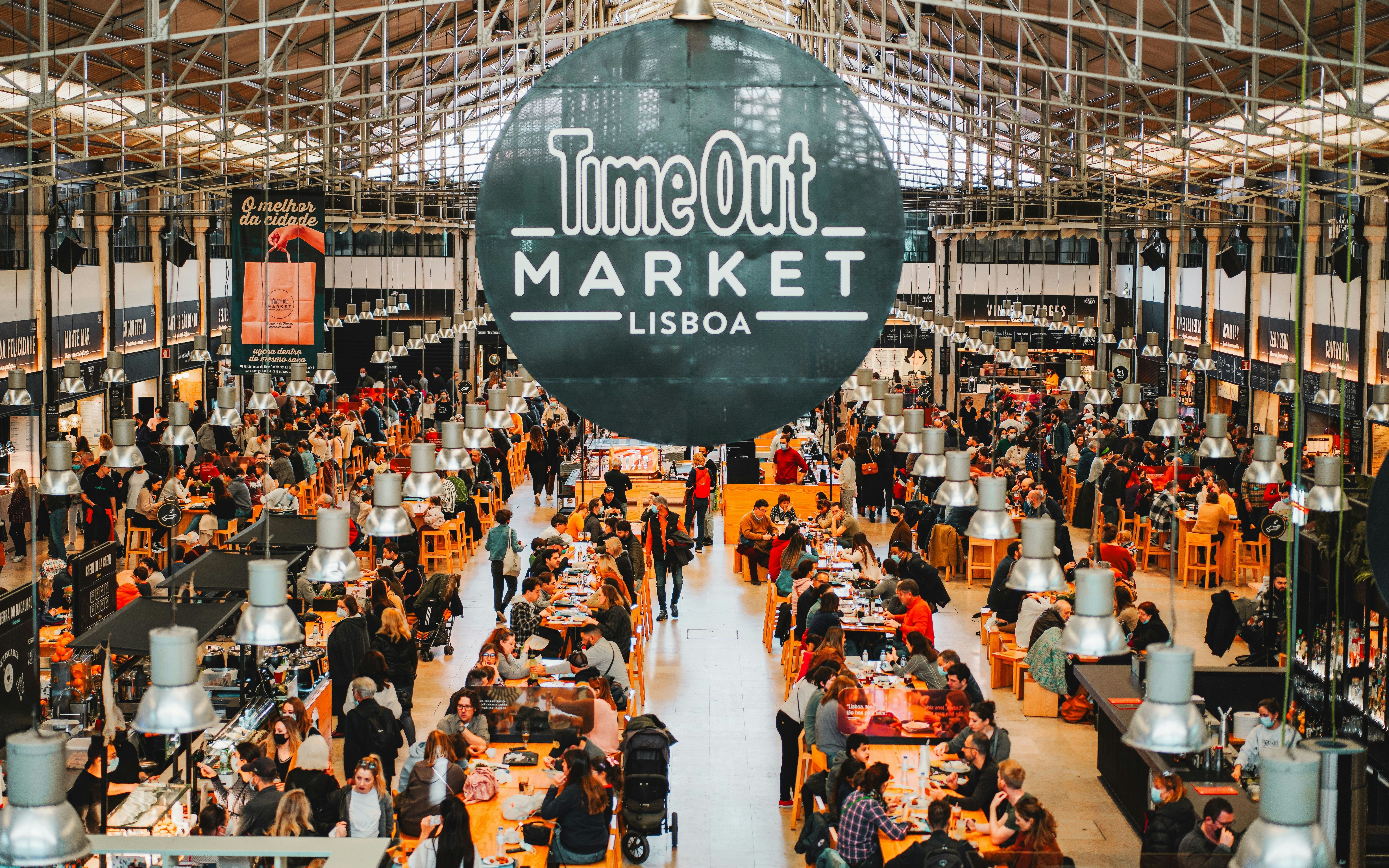 Time Out Market Lisbon interior with people dining and exploring food stalls.