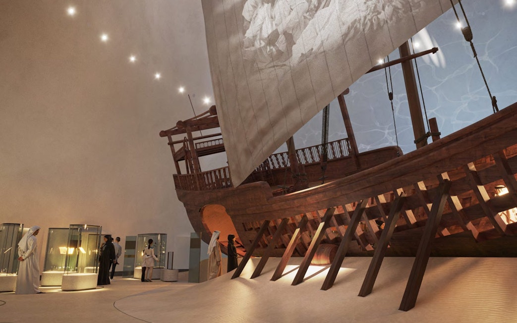 Visitors viewing maritime exhibits at Zayed National Museum, featuring a large traditional wooden ship.