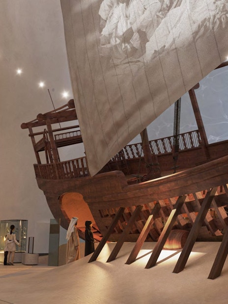 Visitors viewing maritime exhibits at Zayed National Museum, featuring a large traditional wooden ship.