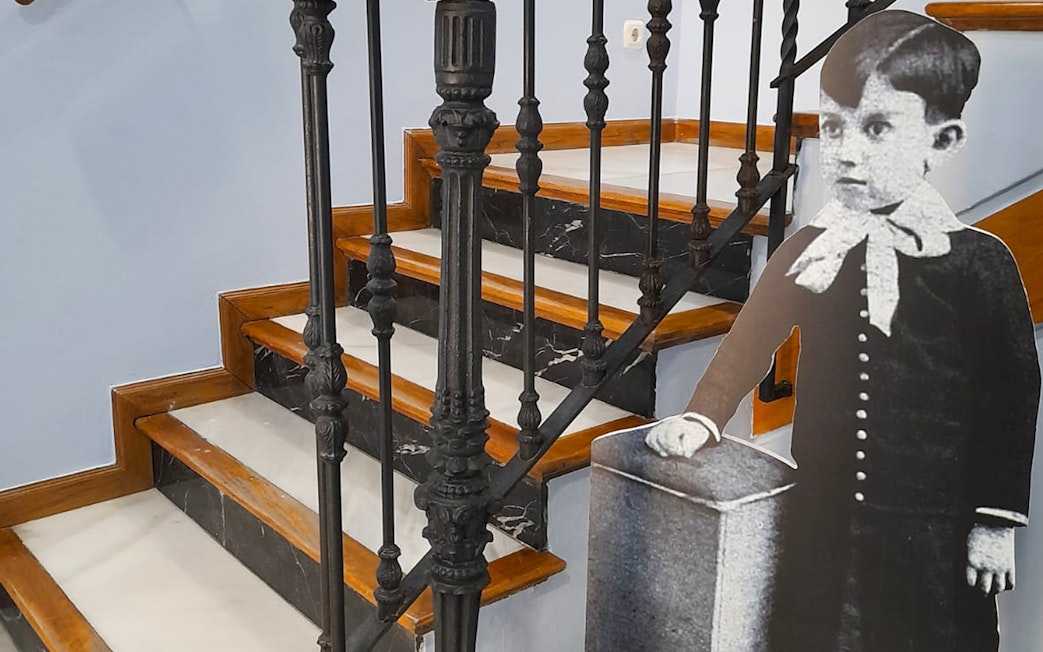 Childhood photo cutout of Picasso by staircase inside Picasso's Birthplace Museum.