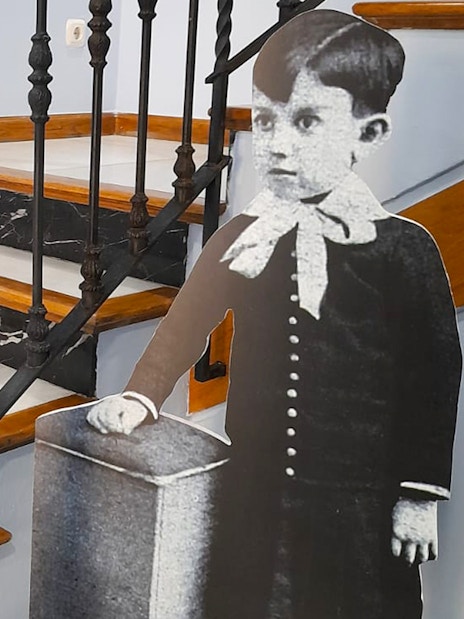 Childhood photo cutout of Picasso by staircase inside Picasso's Birthplace Museum.