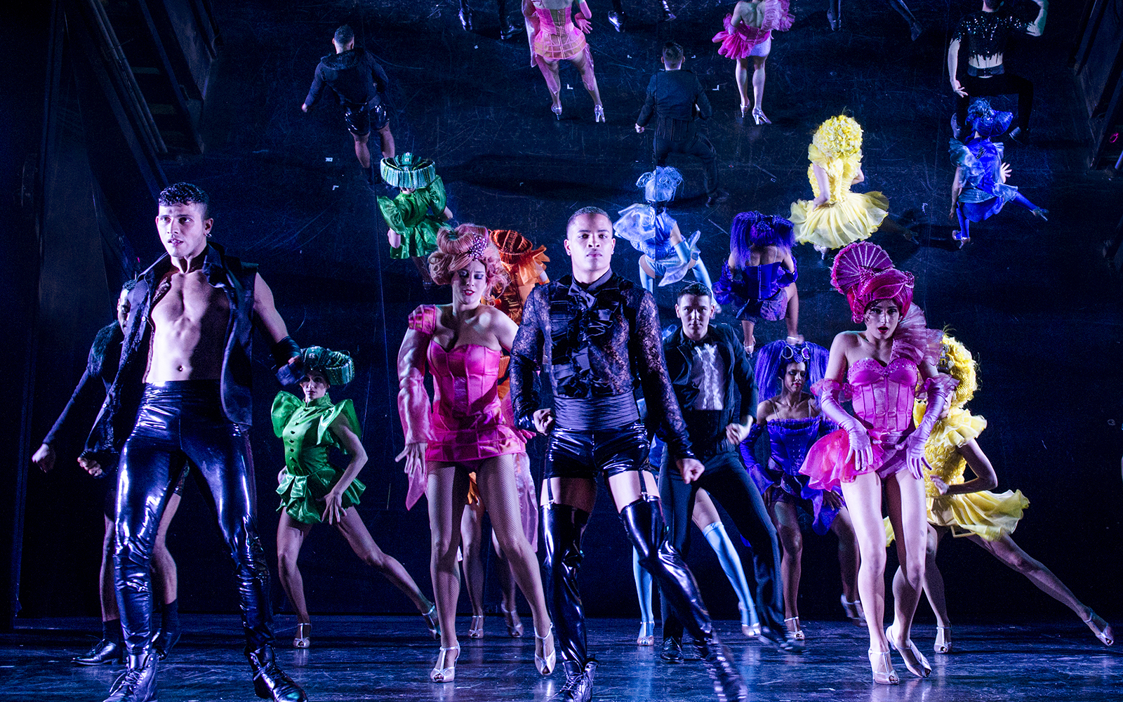 Performers in colorful costumes dancing at Paradis Latin festive show.