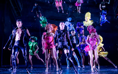 Performers in colorful costumes dancing at Paradis Latin festive show.