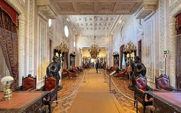 Interior of Pena Palace in Sintra, featuring ornate decor and chandeliers.