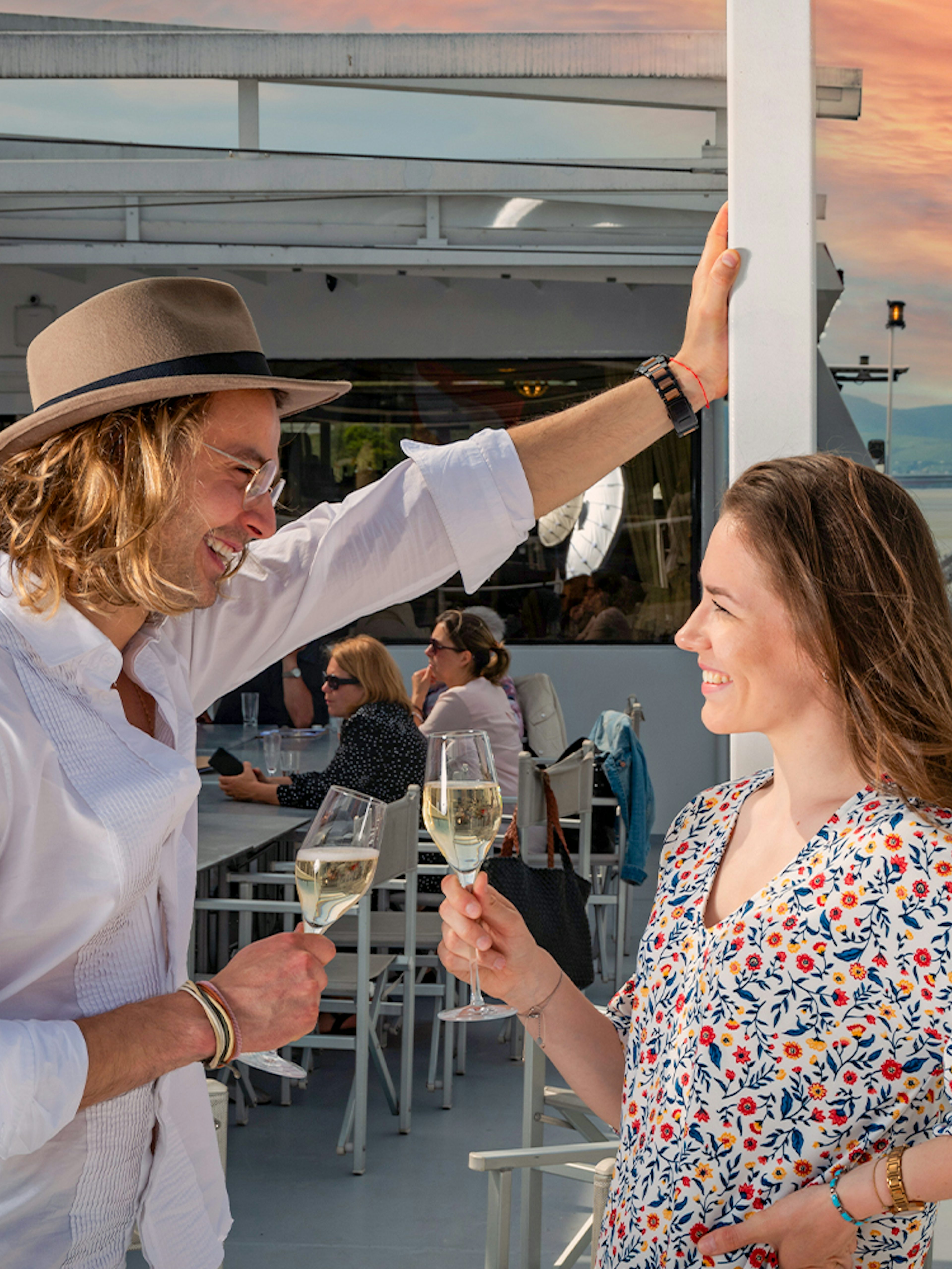 Couple enjoying drinks on a Wachau cruise from Vienna at sunset.