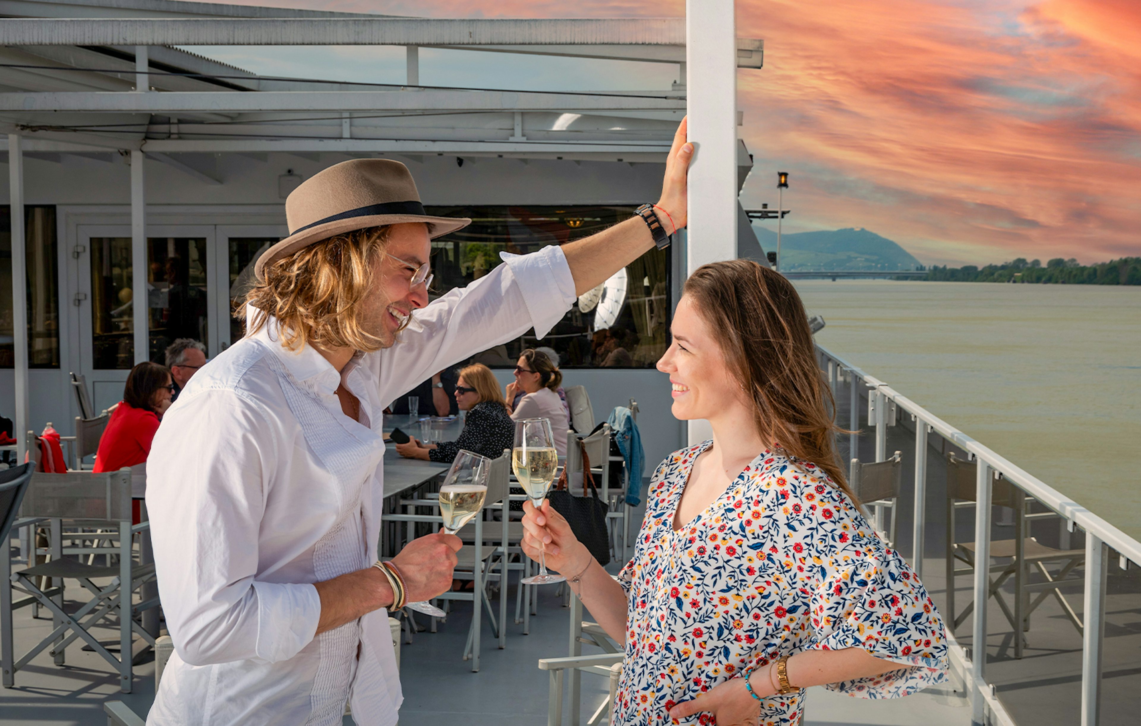 Couple enjoying drinks on a Wachau cruise from Vienna at sunset.