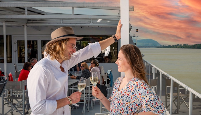 Couple enjoying drinks on a Wachau cruise from Vienna at sunset.