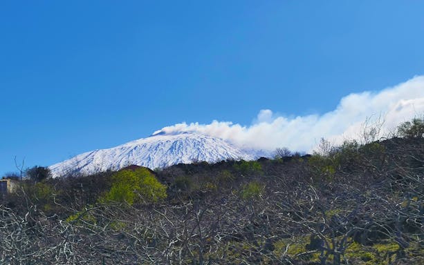 Mount Etna with smoke rising, viewed from Etna Park during a jeep tour.