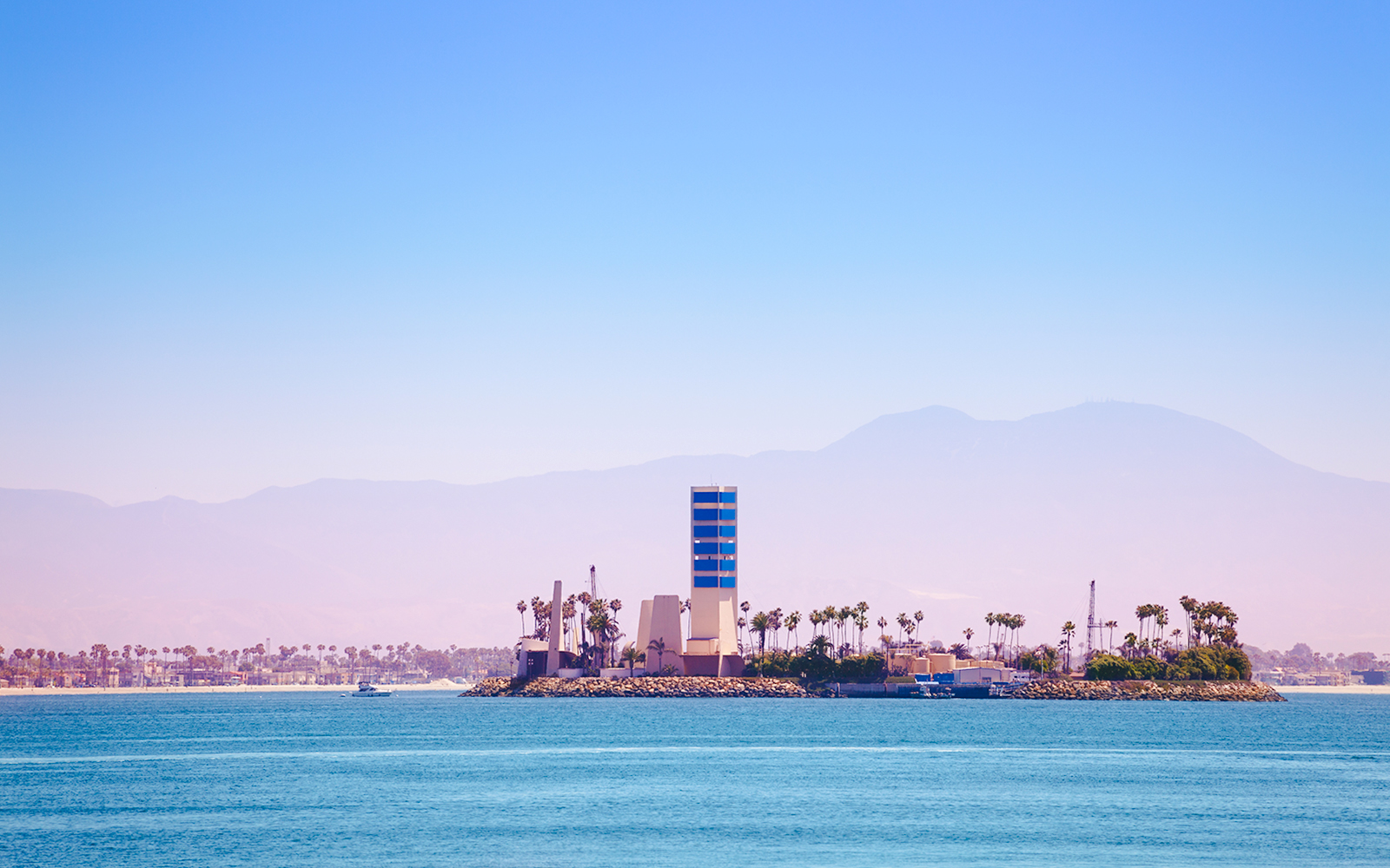 THUMS Islands with palm trees and a tall structure in Long Beach, California.