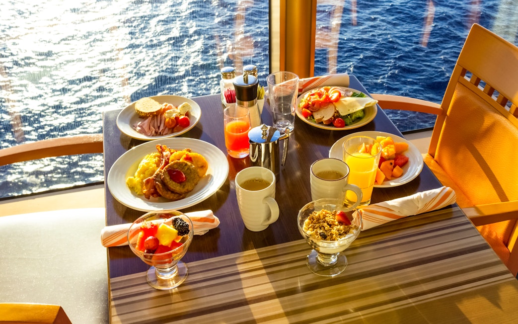 Dinner table with assorted dishes and drinks on a cruise in Ho Chi Minh City.