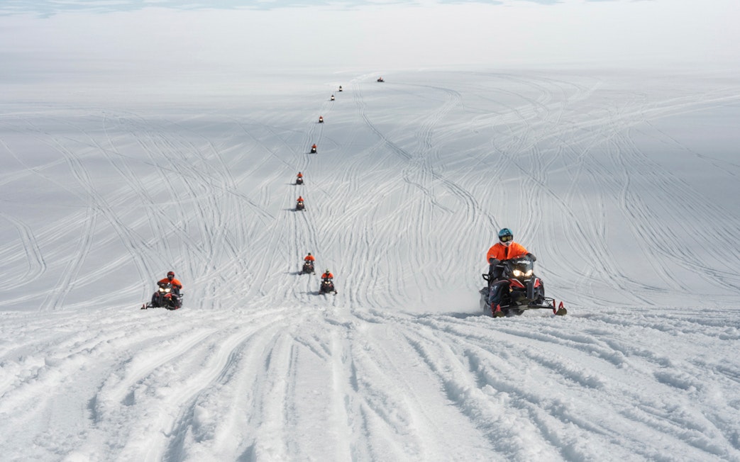 Snowmobilers traversing Langjökull Glacier in Iceland.