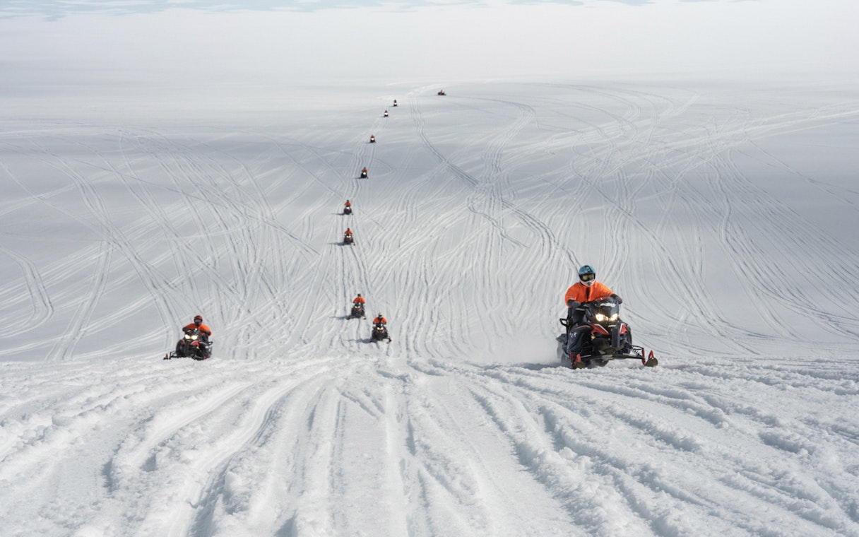 Snowmobilers traversing Langjökull Glacier in Iceland.