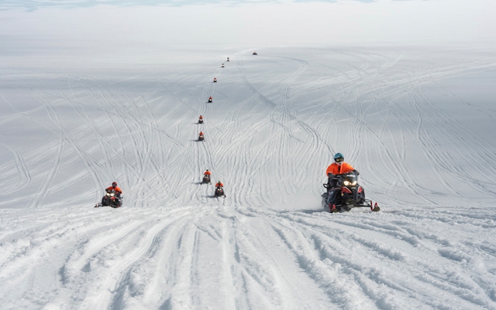 Snowmobilers traversing Langjökull Glacier in Iceland.