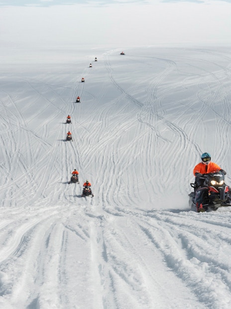 Snowmobilers traversing Langjökull Glacier in Iceland.