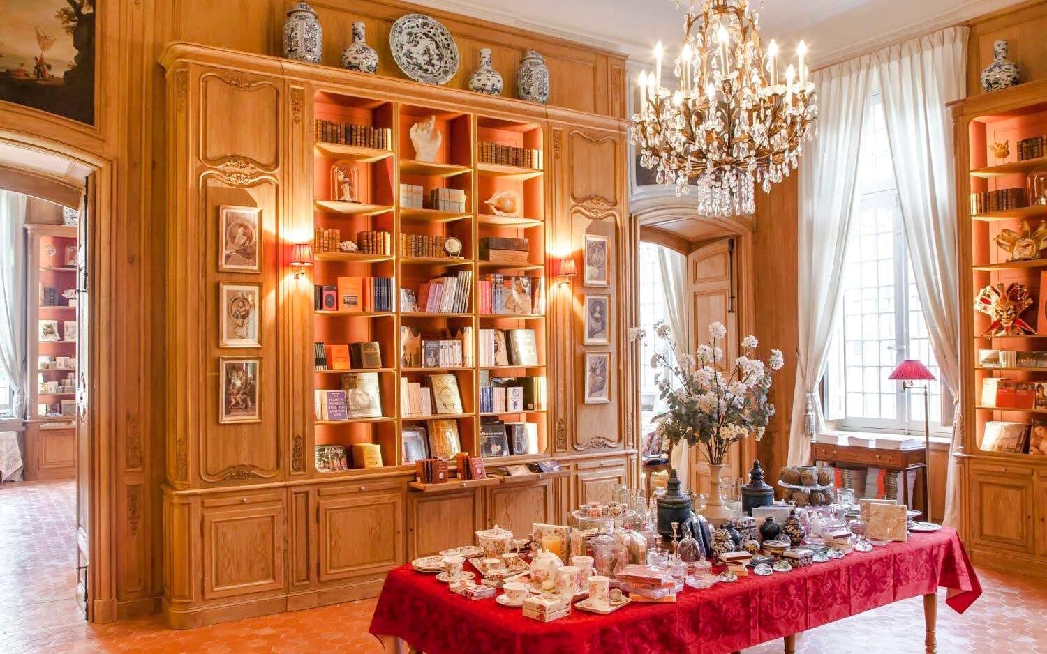 Elegant interior of Caumont Centre d’Art with bookshelves and a table set for tea.