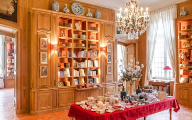 Elegant interior of Caumont Centre d’Art with bookshelves and a table set for tea.