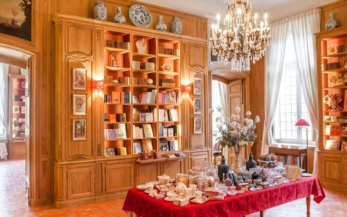 Elegant interior of Caumont Centre d’Art with bookshelves and a table set for tea.