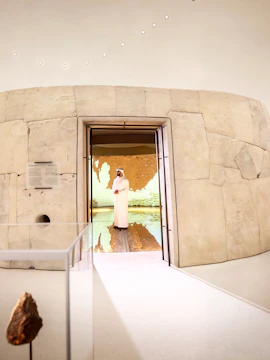 Visitors exploring ancient artifacts at Zayed National Museum exhibit, Abu Dhabi.