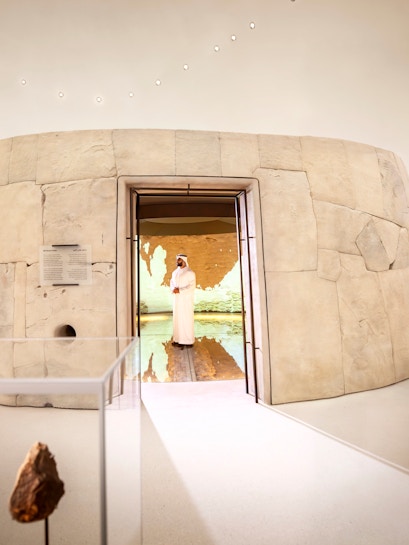 Visitors exploring ancient artifacts at Zayed National Museum exhibit, Abu Dhabi.