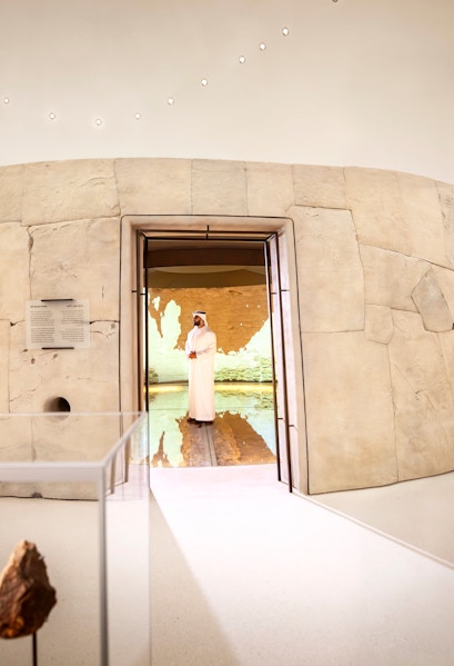 Visitors exploring ancient artifacts at Zayed National Museum exhibit, Abu Dhabi.