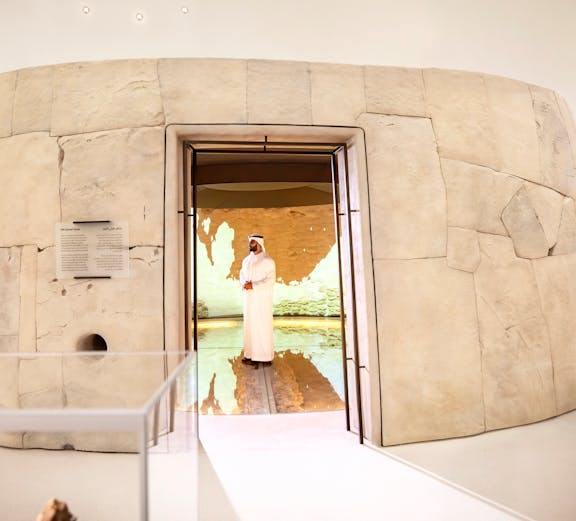 Visitors exploring ancient artifacts at Zayed National Museum exhibit, Abu Dhabi.
