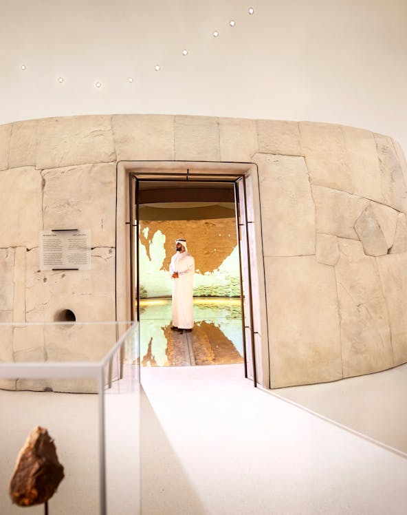 Visitors exploring ancient artifacts at Zayed National Museum exhibit, Abu Dhabi.