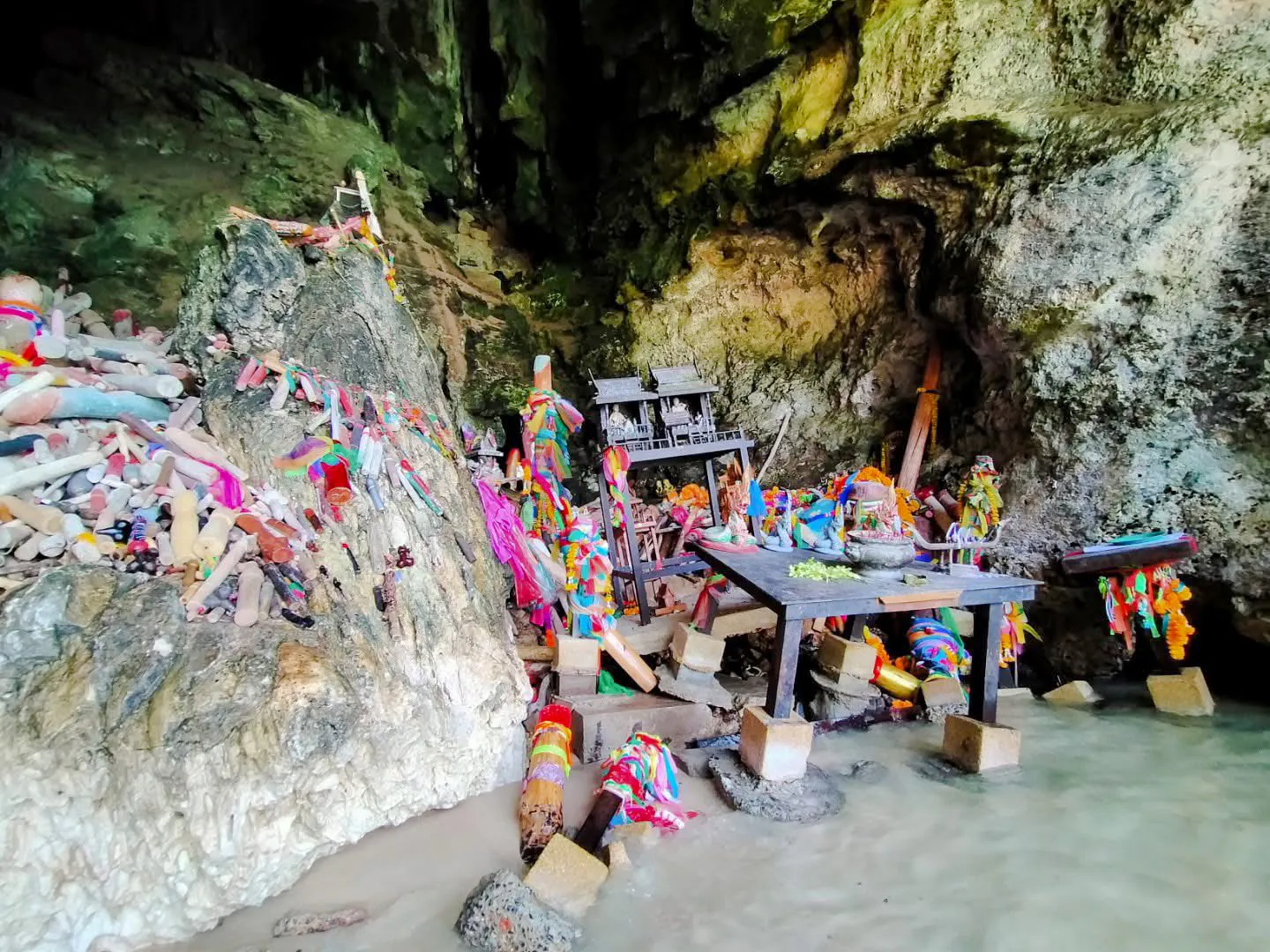 Shrine with colorful offerings inside a cave on the Krabi 7 Islands Sunset Tour.
