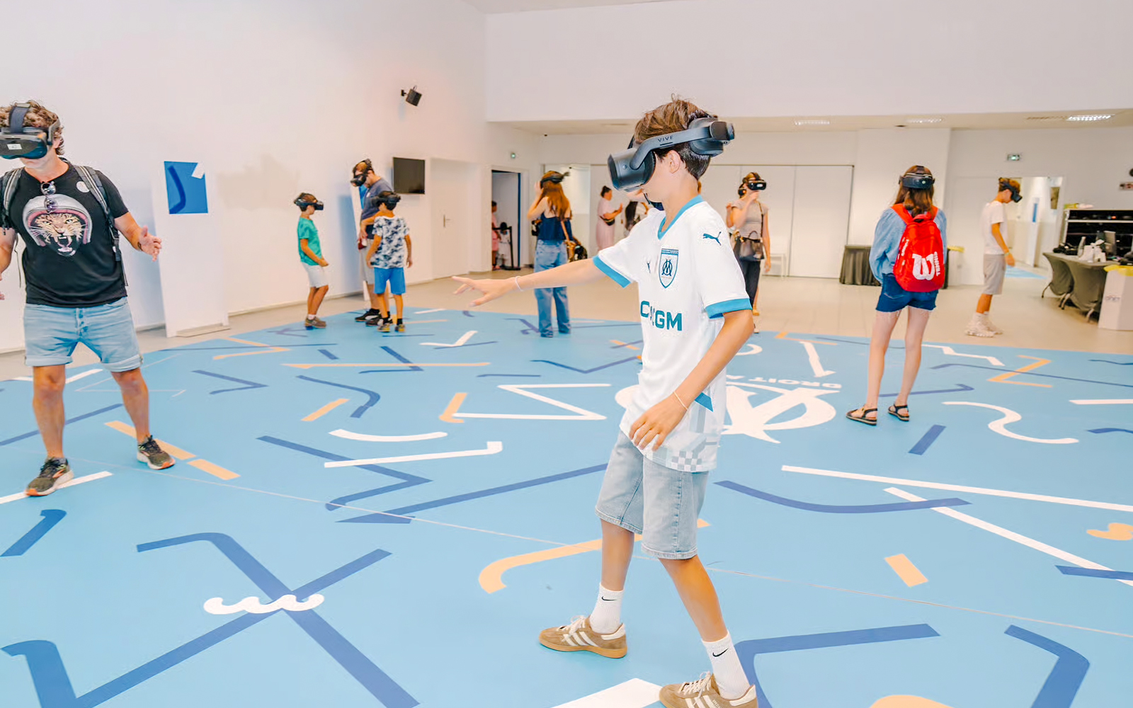 Visitors experiencing virtual reality at Velodrome stadium tour.