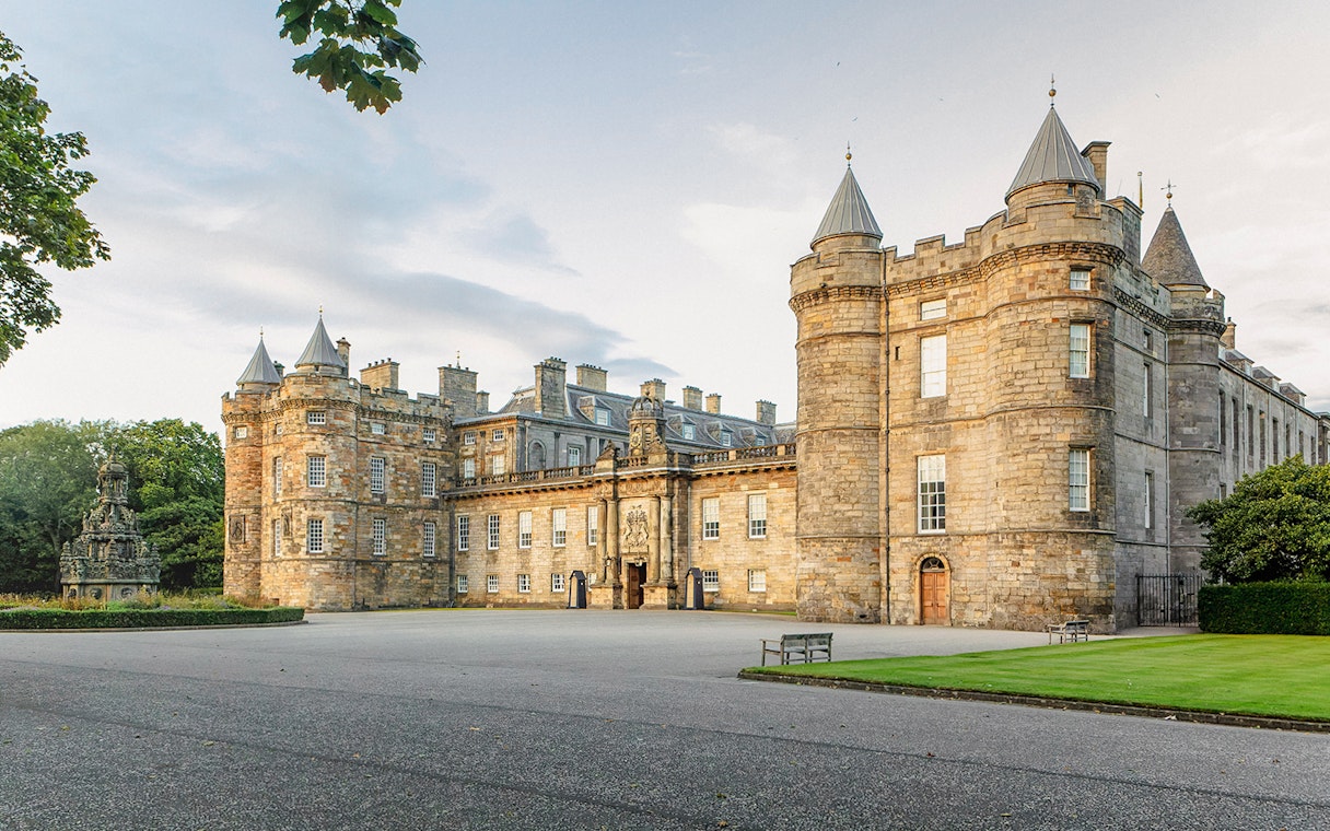 Tourists exploring the historic Palace of Holyroodhouse in Edinburgh, Scotland.