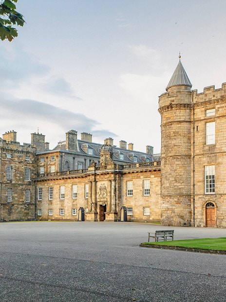 Tourists exploring the historic Palace of Holyroodhouse in Edinburgh, Scotland.