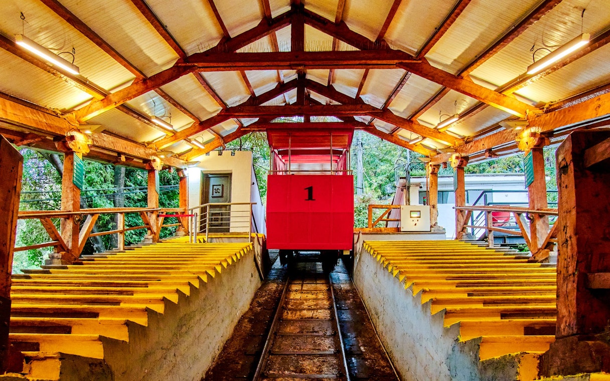 Santiago cable car station with red car and wooden beams.