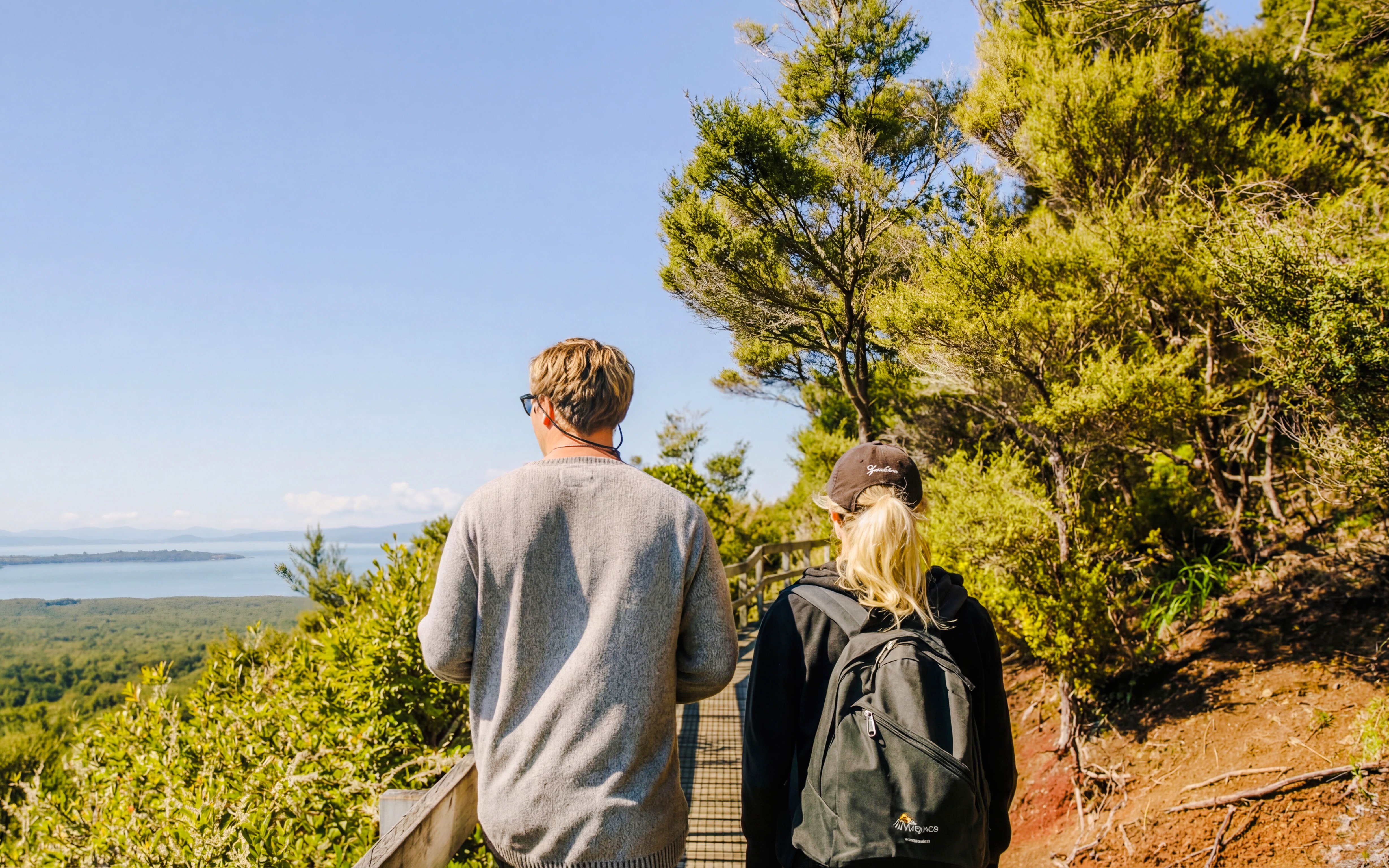Visitors walking on a trail with views of Rangitoto Island, Auckland.