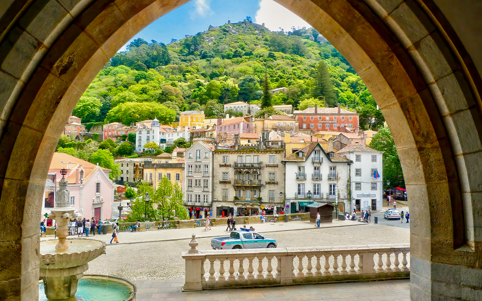 Sintra town square with colorful buildings and lush hillside view.
