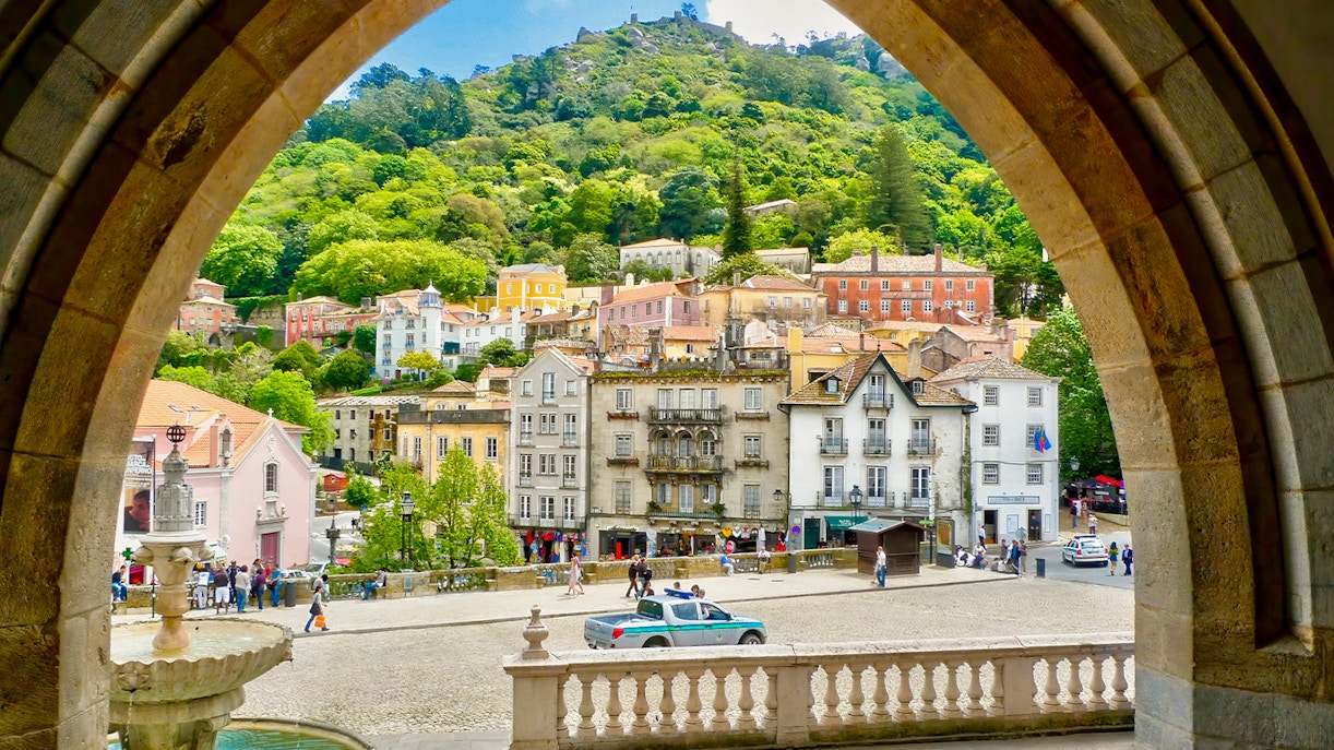Sintra town square with colorful buildings and lush hillside view.