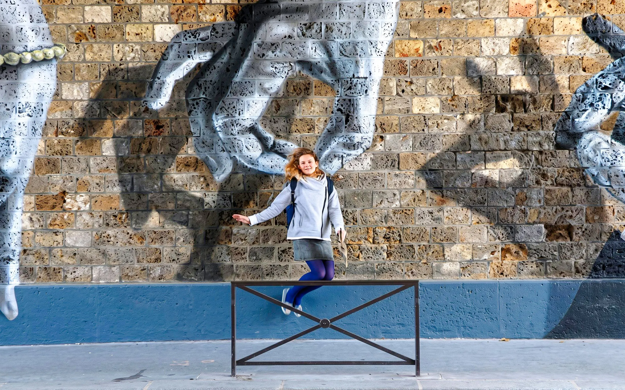 Montmartre street art mural with a person posing in front, Paris tour.