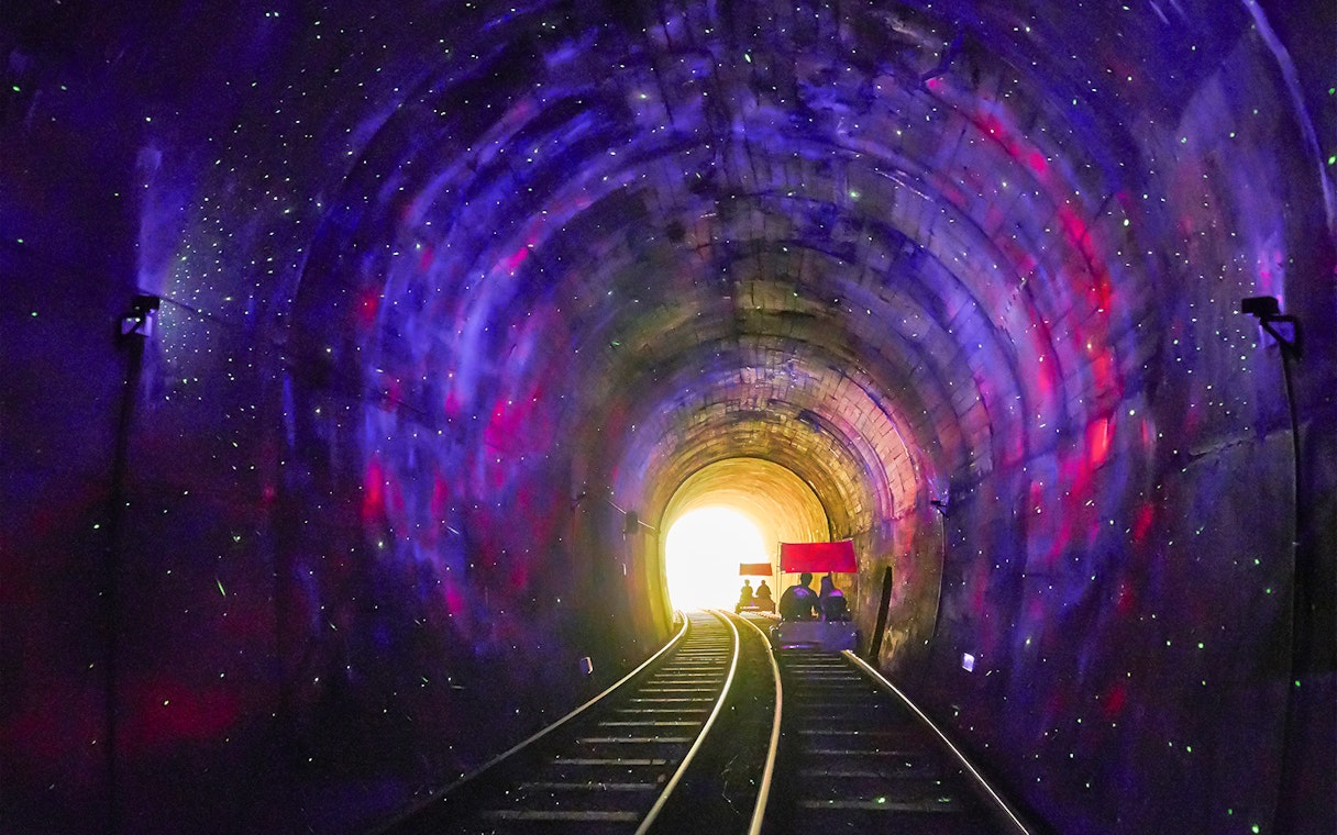 Railbike ride through illuminated tunnel on Gangchon Railbike Day Tour, Korea.