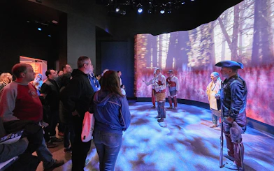 Visitors observing a historical reenactment at the Museum of the American Revolution.