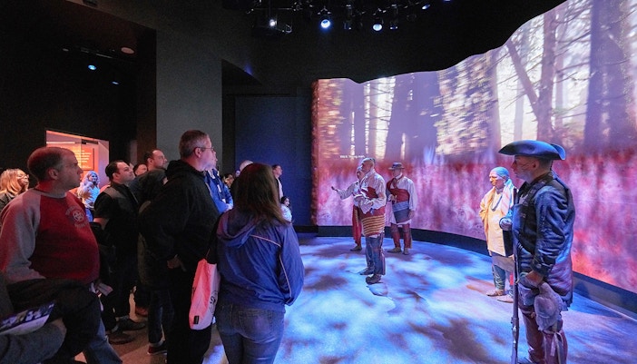 Visitors observing a historical reenactment at the Museum of the American Revolution.