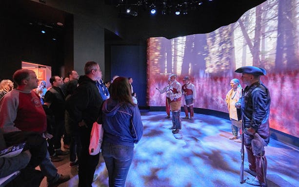 Visitors observing a historical reenactment at the Museum of the American Revolution.