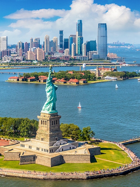Statue of Liberty with New York City skyline during helicopter tour.