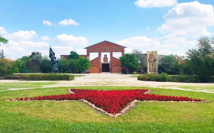 Entrance of Memento Park with red star flowerbed, Budapest.