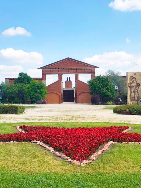 Entrance of Memento Park with red star flowerbed, Budapest.