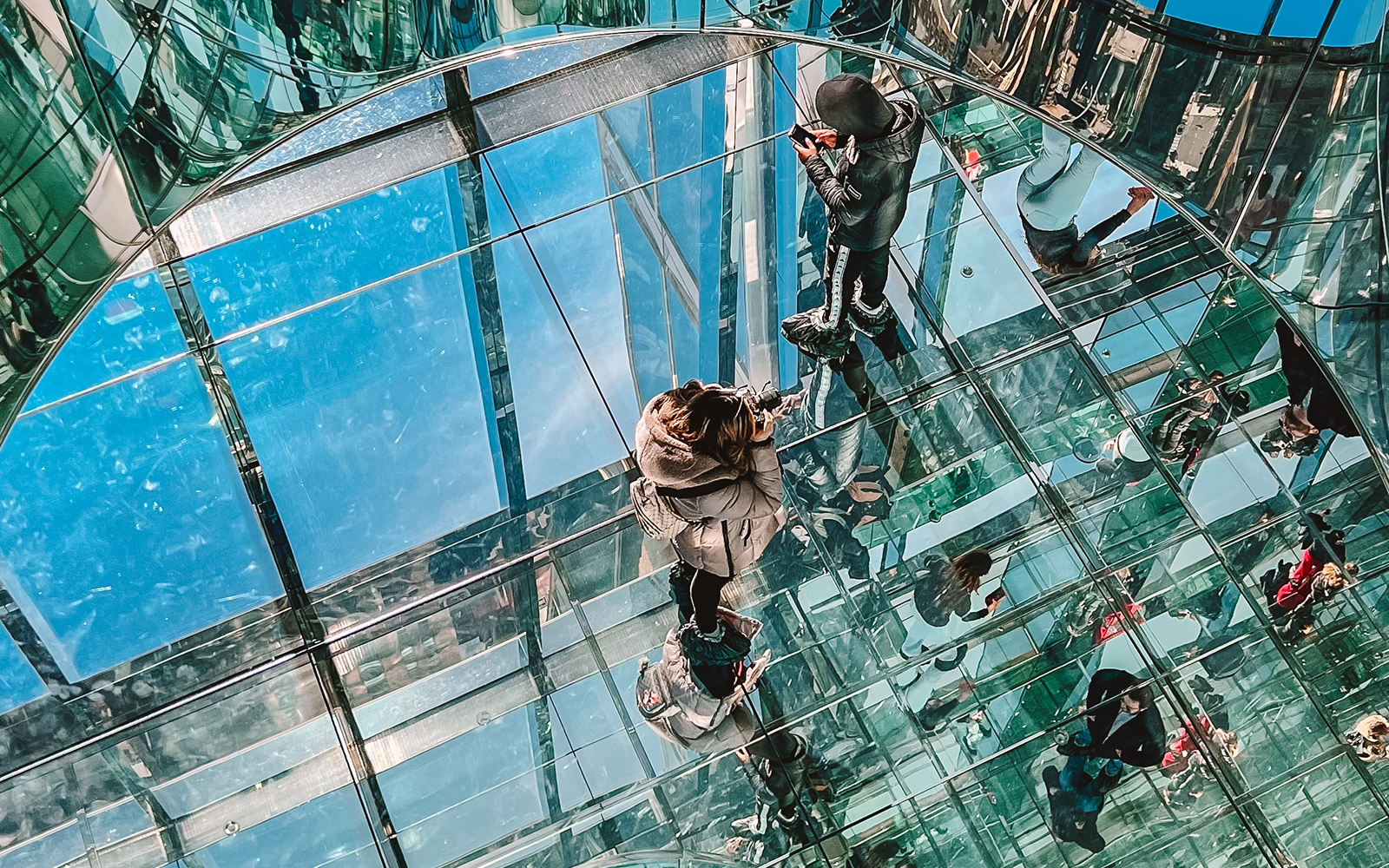 Visitors walking on glass floor at SUMMIT One Vanderbilt, New York City.