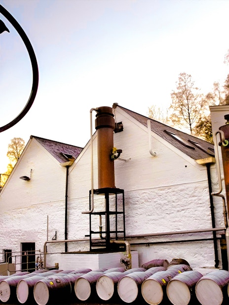 Whisky distillery with barrels and chimney on Edinburgh day tour.