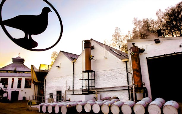 Whisky distillery with barrels and chimney on Edinburgh day tour.