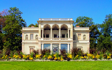 Neoclassical villa with statues and gardens in Geneva.